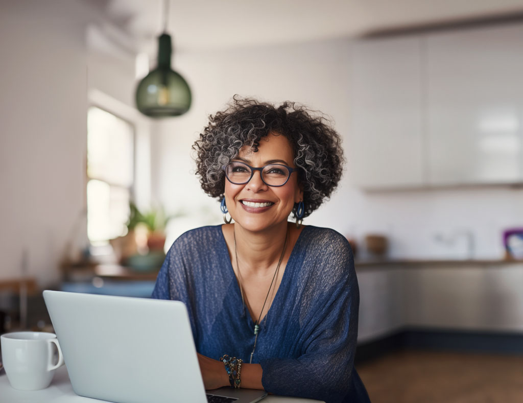 Female advisor taking notes in front of a computer in her home based office about Owl Be There, a franchise to invest in.