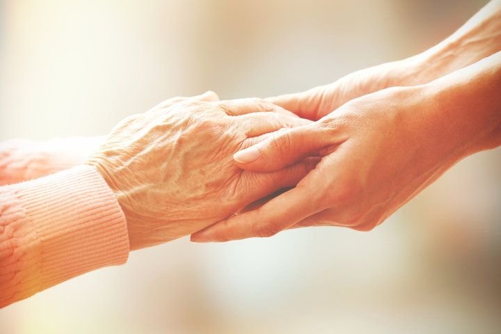 Senior care advisor holding hands with a senior 