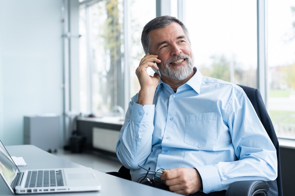 Senior Living Advisor using his mobile phone and talking with potential clients. 