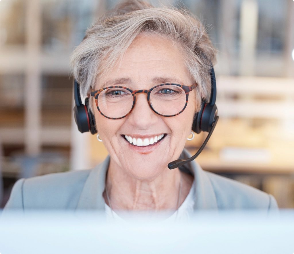 A female senior living advisor on a headset speaking to a potential client.